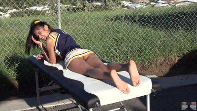 Cheerleader without panties sunbathing on the massage table on youpornvideos.one